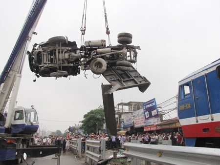 A crane lifts a truck away from the railway tracks where it was struck by an oncoming train on April 6 in Hanoi.(Photo:SGGP)